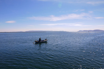 A lone fisherman tries his lucj in Lake Titicaca Peru