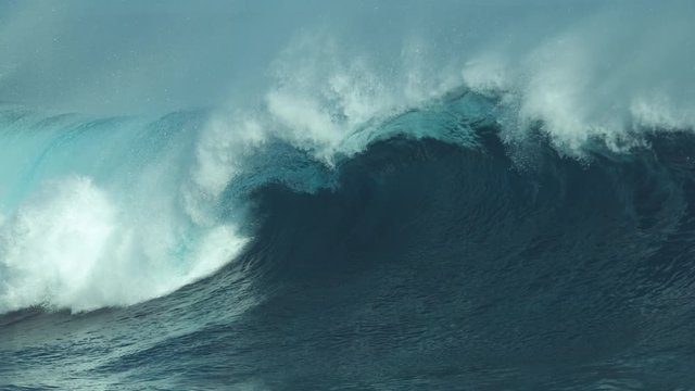 SLOW MOTION, CLOSE UP: Breathtaking shot of emerald colored barrel wave crashing and spraying glistening drops of water over remote tropical island. Spectacular blue ocean swell curling and sparkling.