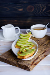 Breakfast with sandwich from avocado and fragrant tea
