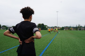 young player on the pitch sidelines watching footballwatching 