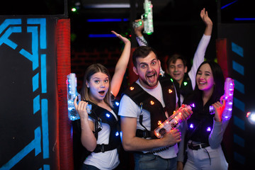 Young people with laser guns on lasertag arena