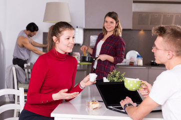 Girl discussing with guy in kitchen of hostel