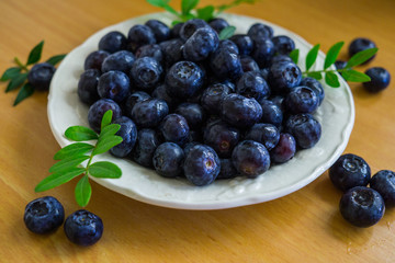 A garden blueberry poured in a saucer on a table