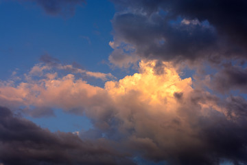 Fototapeta na wymiar The storm cloud is illuminated by the sunbeam