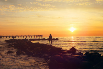 Sea sunset view with bridge and stones pier. Baltic sea in Palanga, Toned.