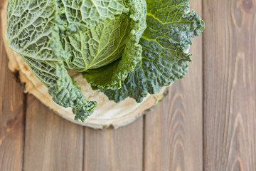 Green fresh cabbage on wooden brown table, savoy