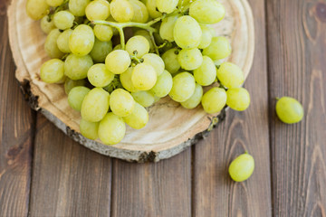 Green fresh grapes on wooden brown table
