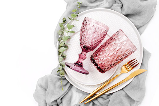 Wedding or festive table setting. Plates, wine glasses and cutlery with gray decorative textile on white background. Beautiful arrangement.
