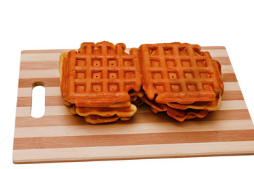 fresh hot wafers lie on a wooden board, isolated on a white background