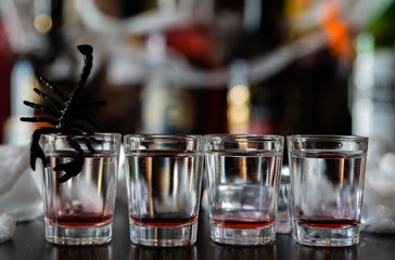 creepy halloween party cocktails with syringes of grenadine syrup as blood, shot drinks at party