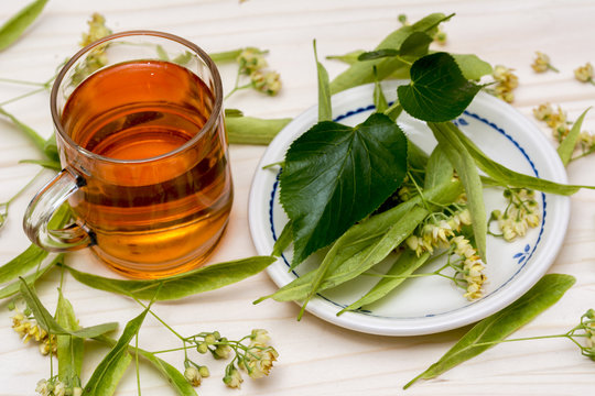 Linden tea in a glass cup blossoms and linden leaves