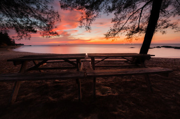wooden table by the beach during sunset with long expose effect.