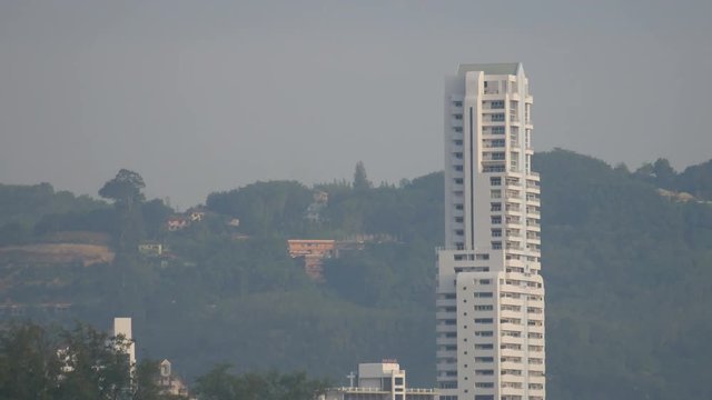 sea wave hit the rock shore seascape , Patong sand beach Phuket  parasail , high building, tree and mountain are  background ,