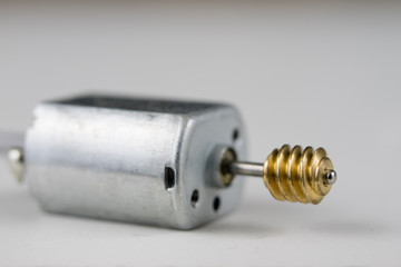Small electric motor on a white workshop table. Electric drive used in small electrical devices.