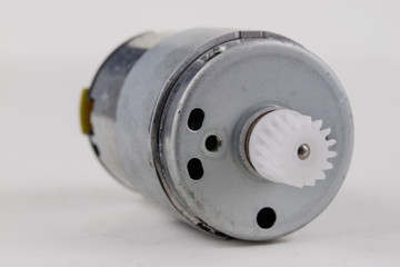 Small electric motor on a white workshop table. Electric drive used in small electrical devices.