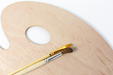 excellent wooden palette with brushes without paint, on a white background.