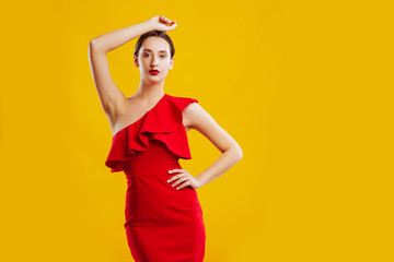 Woman in red dress over yellow background.