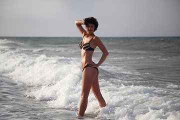 A beautiful woman is basking in the sun in the sea. Young woman sitting on the beach Beautiful adult woman sunbathing on the beach.