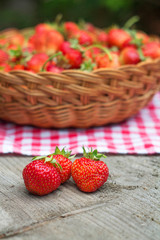three strawberries on a wooden table close-up