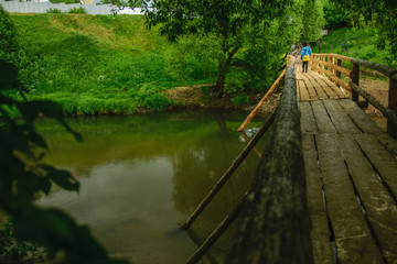 Girl on wooden bridge across river in Russia