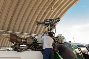 Engineer maintaining a helicopter Engine on the aircraft factory