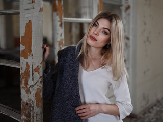 Outdoor lifestyle portrait of beautiful blonde young woman. Posing on urban background. Fashion Photo