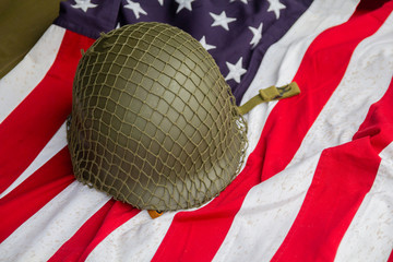 Soldier's helmet and the times of the Second World War and the US flag. Patriotism
