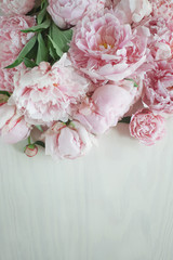Flat lay concept with beautiful peonies on white wood, can be used as background