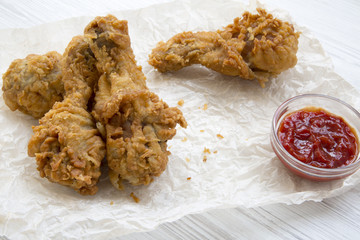 Fried chicken legs with ketchup , side view. Close-up.