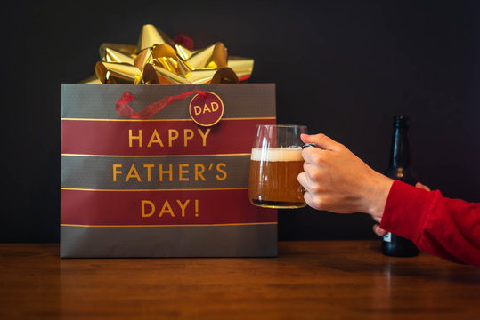 Cheers To Dad - Closeup Of Hand Holding Beer Mug With Happy Father's Day Gift Bag