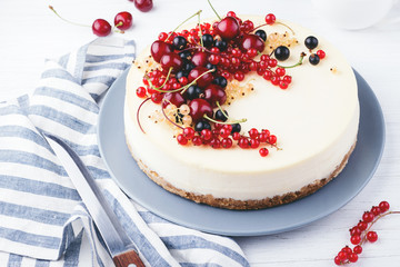 New York cheese cake with berries on white wooden table. Angle view.