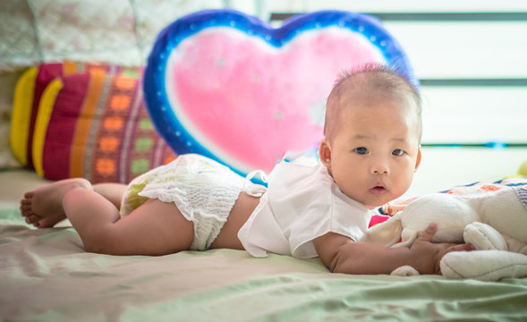 Infant Baby Lie On The Bed With Heart Pillow