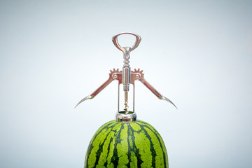 Watermelon being opened by a bottle opener for a fresh taste