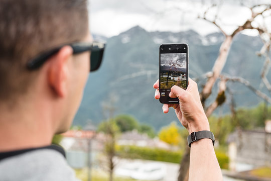 Man making photo of nature landscape on smartphone