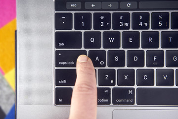 working on the laptop , work on the notebook Women or man finger click caps lock button on keyboard...