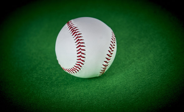 Baseball ball isolated on green felt background