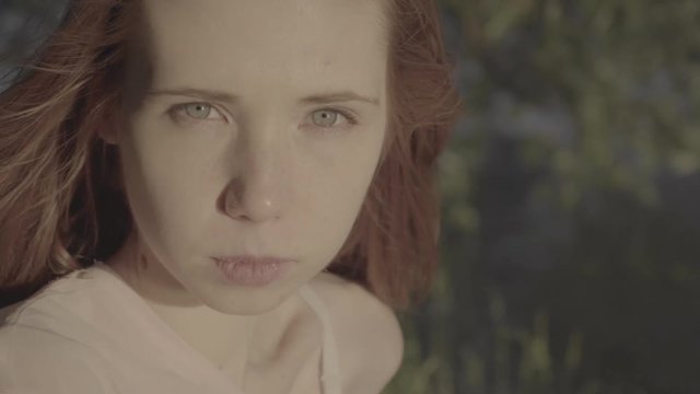Portrait of a beautiful red-haired positive girl in a park, color profile Slog3