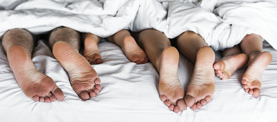 Whole family sharing a bed - obrazy, fototapety, plakaty