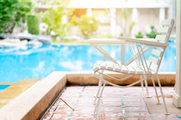 Swimming pool with umbrellas and chairs for relaxing in the hotel. heavy light and bokeh. Tech little artificial light.