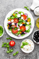 Greek salad. Fresh vegetable salad with tomato, onion, cucumbers, pepper, olives, lettuce and feta cheese. Greek salad on plate