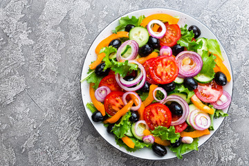 Greek salad. Fresh vegetable salad with tomato, onion, cucumbers, pepper, olives, lettuce and feta cheese. Greek salad on plate