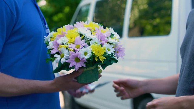 Male paying courier for flowers delivery, anniversary present, birthday gift