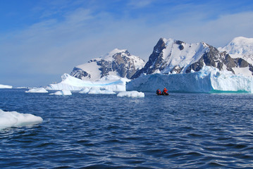  Antarctica, a small boat cruising around icebergs