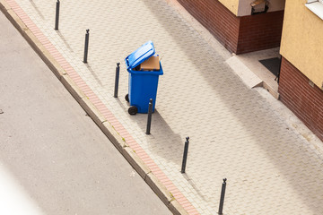 Obraz na płótnie Canvas Blue trash can on street pavement