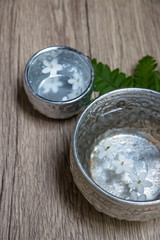 Water in silver bowl with white flower. Thailand Songkran festival decoration concept.