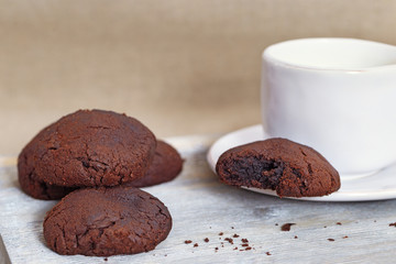 Chocolate cookies with milk on wooden desk. Sweet breakfast. Copy space.