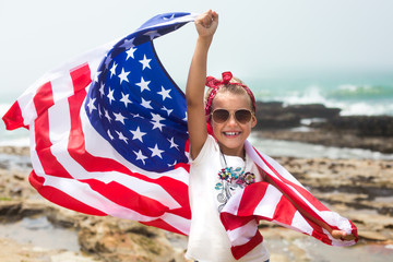 Independence day celebration with american flag. Smiling patriotic girl holds US flag celebrating national Holiday Independence day