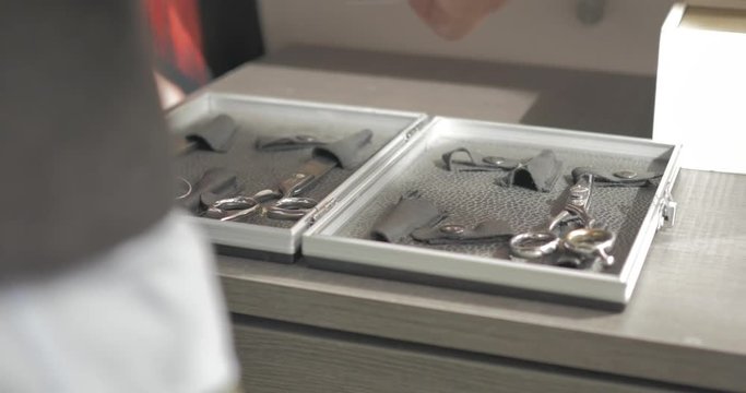 Male hairdresser sorting and picking up scissors at a salon. Focus pull.