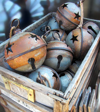 Vintage Christmas Bells at a Texas Flea Market.
Large rustic metal ball in retro style lying in a wooden box.