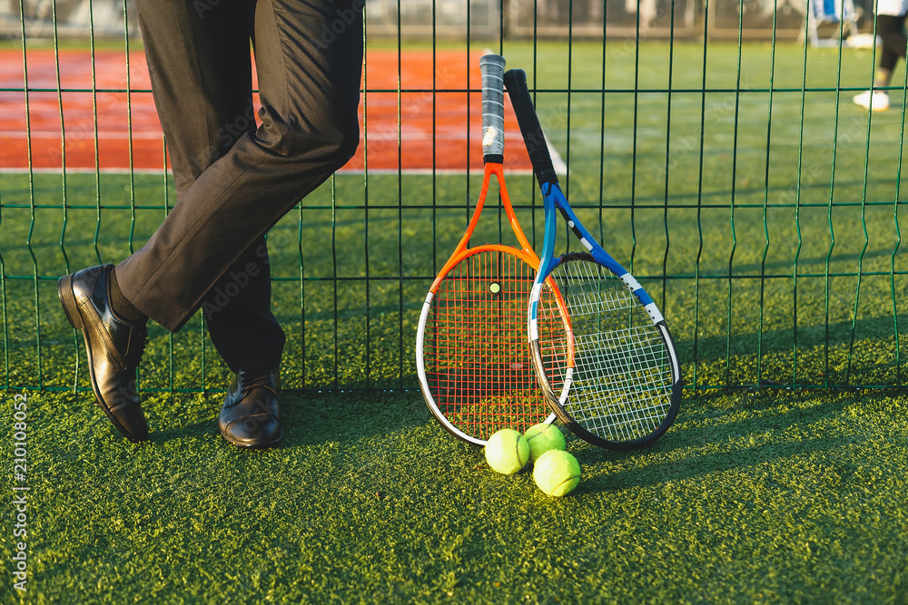 Wall mural Businessman on tennis court with tennis equipment